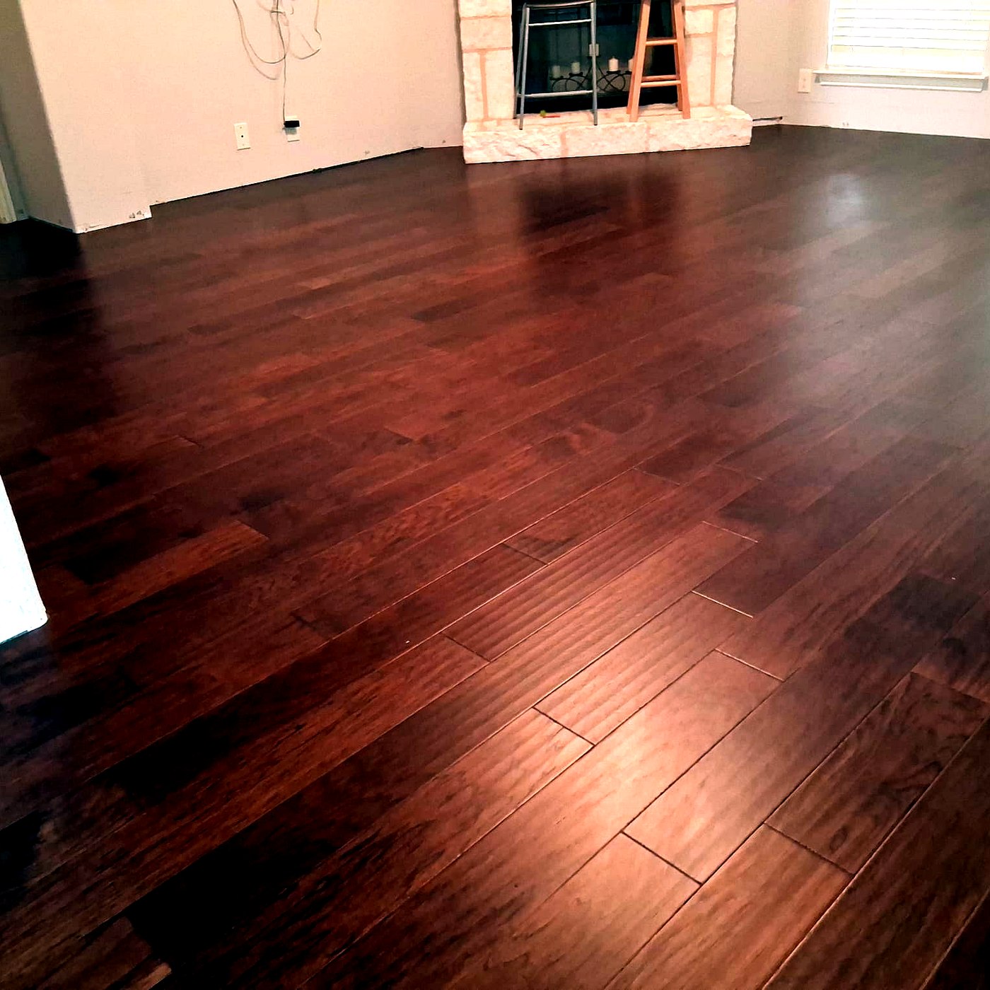 FloorFlash cherry-toned hardwood floor installed in a Dallas-area living room with stone fireplace