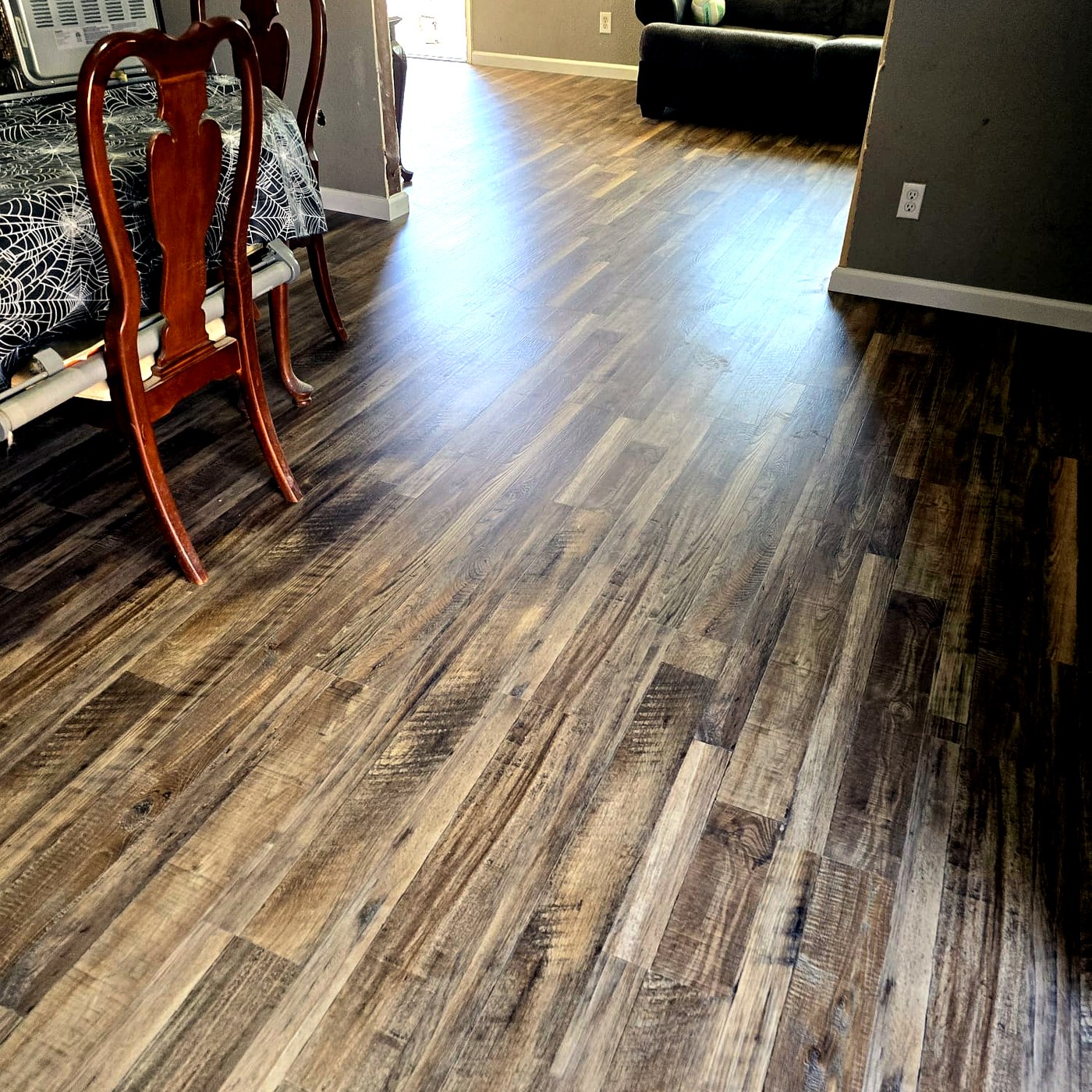 FloorFlash variegated multi-tone hardwood plank floor installed in a Dallas-area dining room with cherry-finished chairs