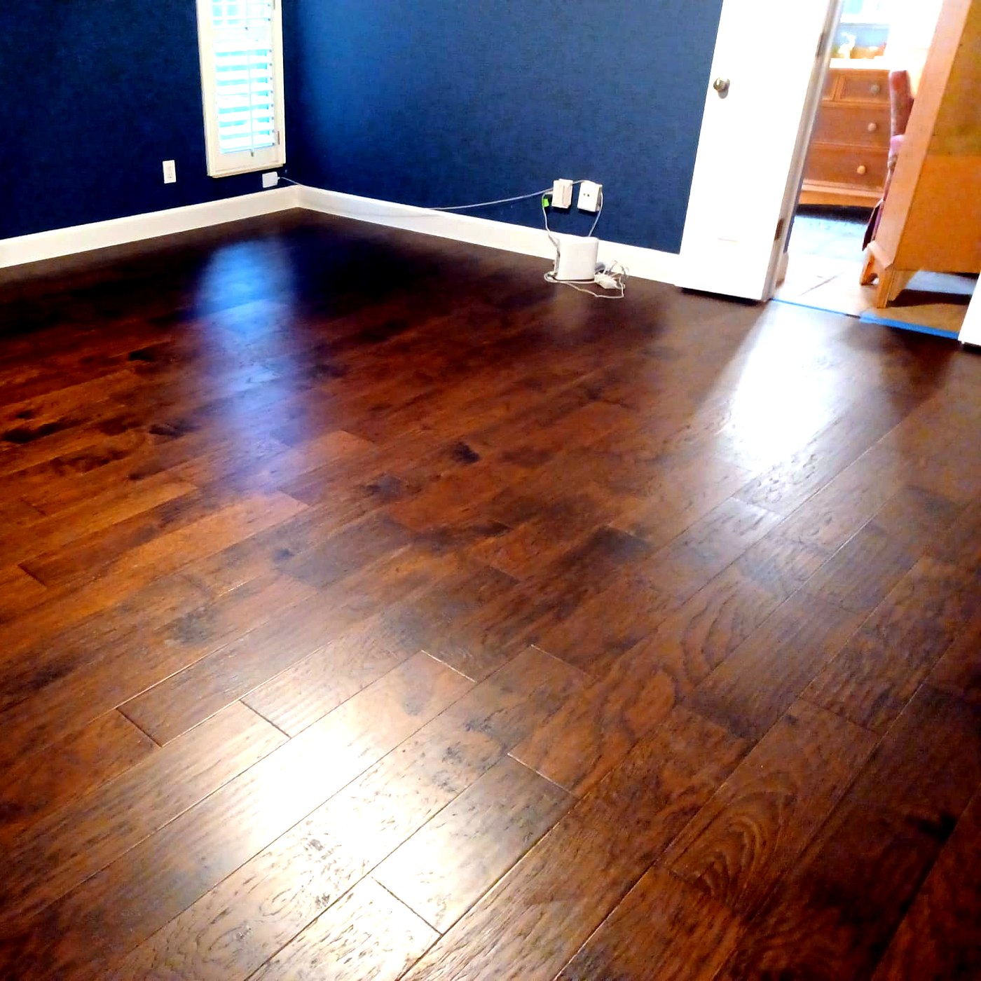 FloorFlash dark hand-scraped hardwood installation in a Dallas-area room with navy accent wall