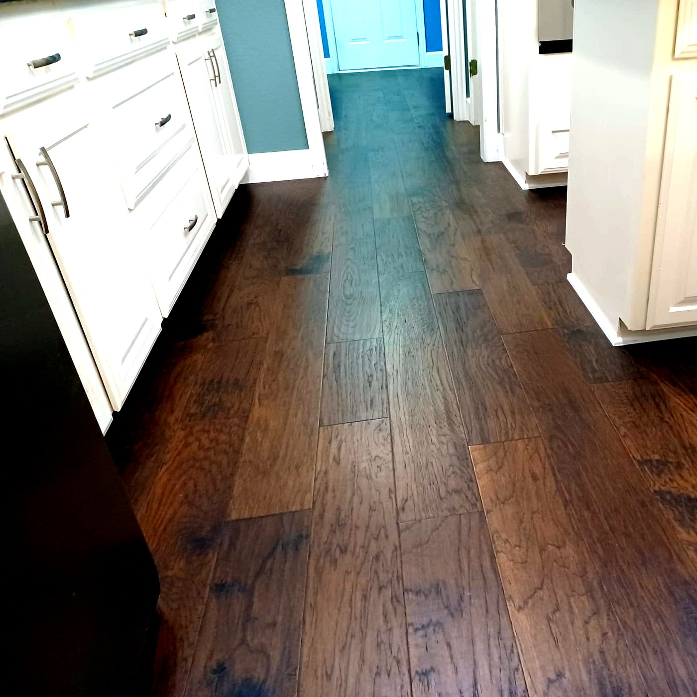 FloorFlash dark hand-scraped hardwood installation in a DFW living room with navy accent wall and white plantation shutters