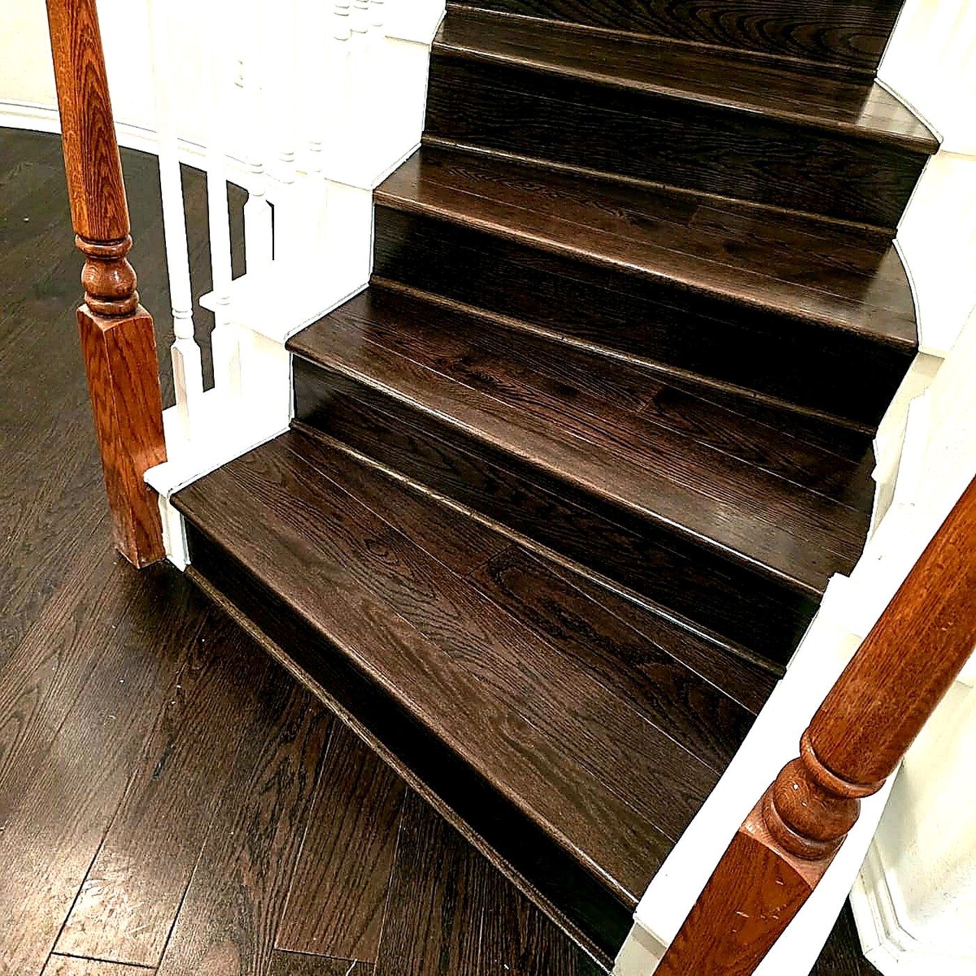 FloorFlash signature two-tone staircase install in DFW: white risers, espresso treads, turned wood newel post
