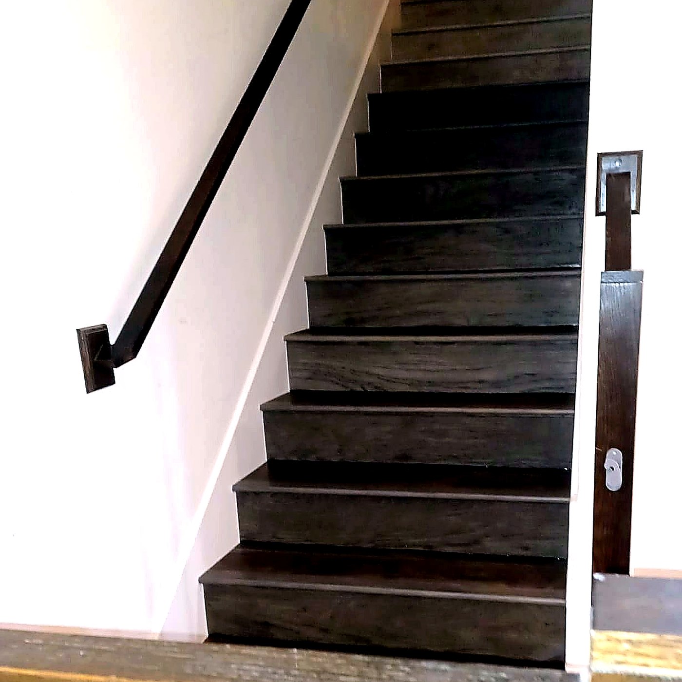 FloorFlash charcoal stained staircase install in DFW with brass-detail handrail bracket