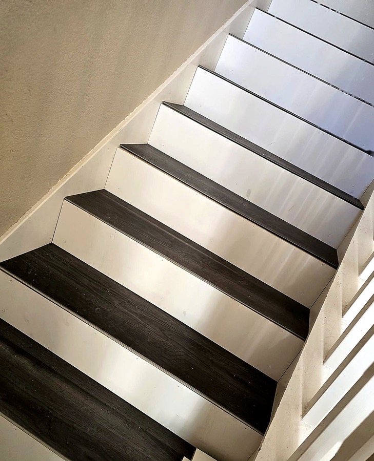 FloorFlash signature two-tone staircase install overhead view: charcoal treads, crisp white risers, DFW custom finish