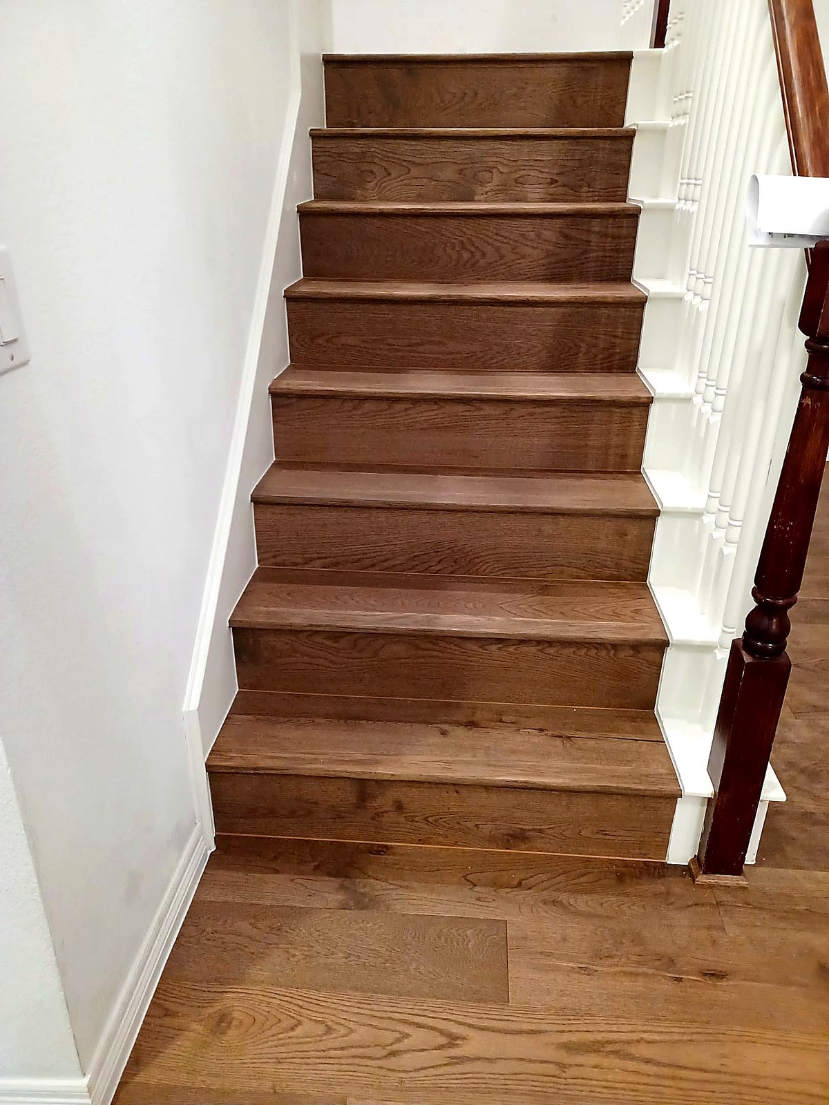 FloorFlash smoked oak straight staircase install in DFW with cherry-stained newel post and white spindles